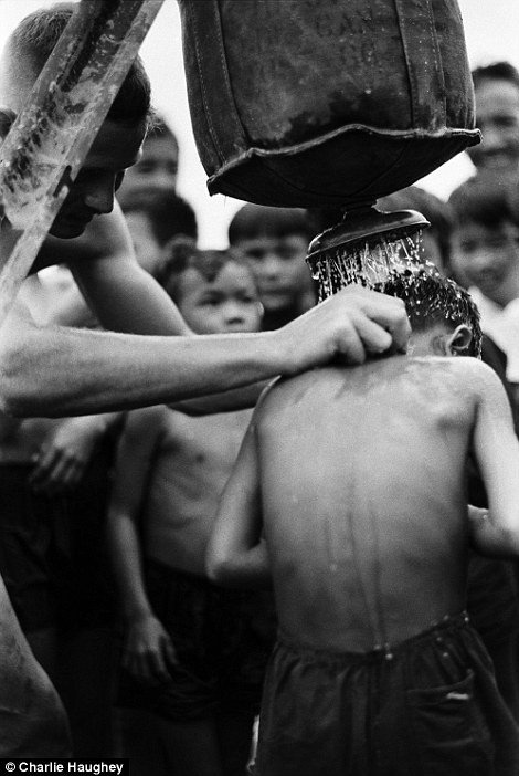 Relief: A medic gives Vietnamese children a shower using a Lyster Bag (left). Right, a soldier guides a Chinook delivering materials to Fire Support Base Pershing near Dau Tieng Read more: http://www.dailymail.co.uk/news/article-2303845/Never-seen-images-Vietnam-War-eyes-soldier-hid-photographs-decades.html#ixzz2PYZ9CsVH Follow us: @MailOnline on Twitter | DailyMail on Facebook