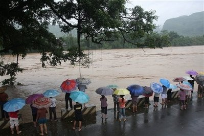 Người dân địa phương tại Luocheng thuộc khu tự trị người Choang, Quảng Tây nhìn dòng nước lũ chảy xiết.