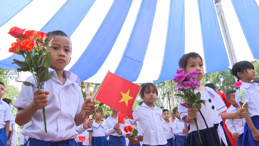 Học sinh miền núi Quảng Trị cầm hoa và cờ Tổ quốc tham gia Lễ khai giảng.