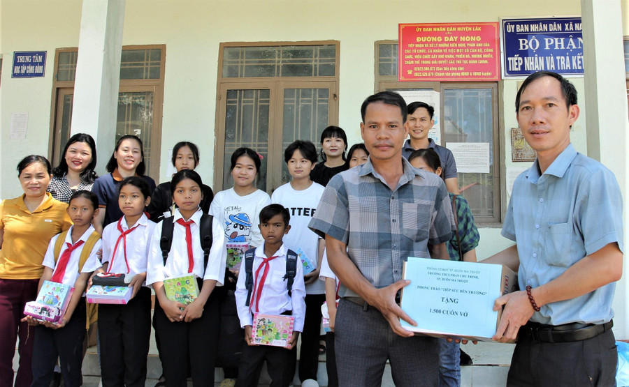 Ông Y Huế Mlô - Phó Bí thư Đảng uỷ xã Nam Ka đại diện các em học sinh đón nhận những phần quà từ ông Võ Ngọc Nam - Hiệu trưởng Trường THCS Phan Chu Trinh.