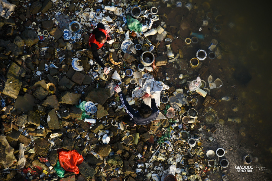 Tro được gom vào bao tải, buộc dây và thả từ trên cầu xuống gầm cầu, sau đó các tình nguyện viên tiếp nhận và thả xuống nước.