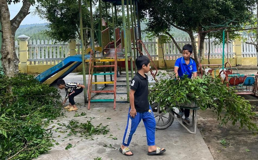 Các em học sinh huyện Kon Plông hỗ trợ thầy, cô dọn cây xanh đã cắt tỉa.