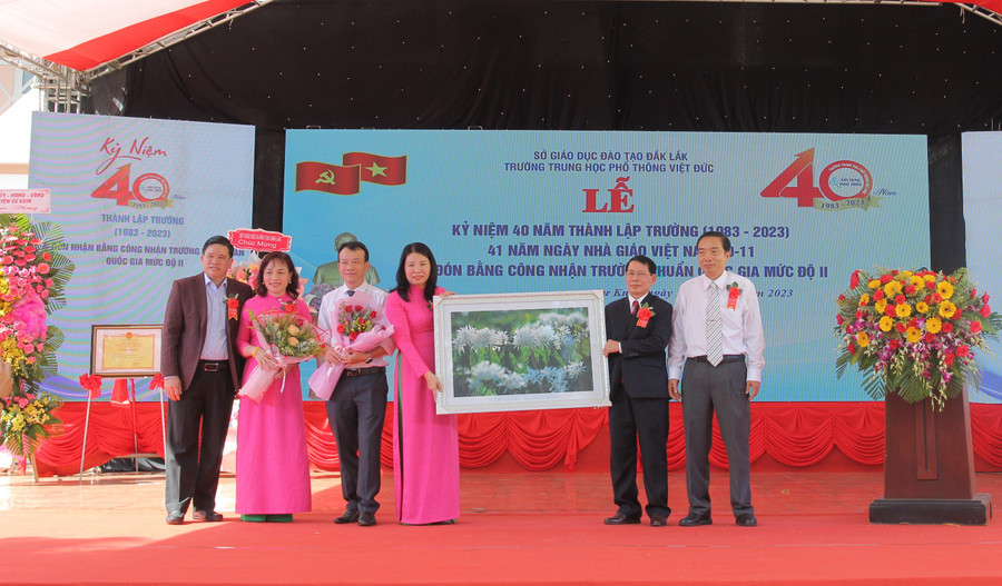 Thầy Lương (thứ 2 từ phải qua) cùng các thầy, nguyên Hiệu trưởng Nhà trường tặng quà chúc mừng dịp kỷ niệm 40 năm thành lập. (Ảnh: TT)