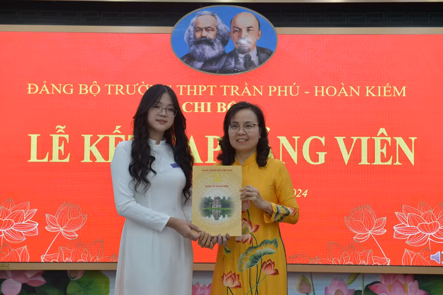 Bí thư Đảng ủy, Hiệu trưởng trường THPT Trần Phú Trần Thị Hải Yến trao quyết định kết nạp cho đảng viên mới Trần Linh Đan.