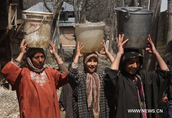 Women carry bockets of water from a stream in a village in Anantnag district, some 55 km south of Srinagar, Kashmir, March 21, 2011.
