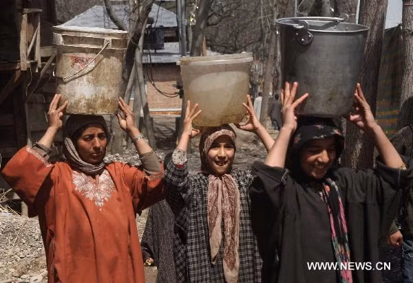Women carry bockets of water from a stream in a village in Anantnag district, some 55 km south of Srinagar, Kashmir, March 21, 2011.