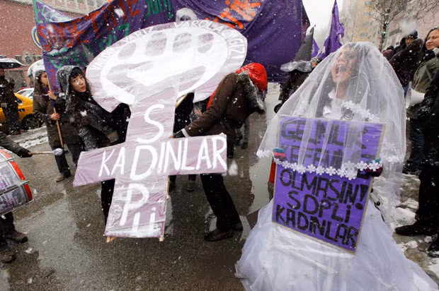 Turkish women shout slogans as they march through Ankara to commemorate International Women’s Day. The banner on the right reads 
