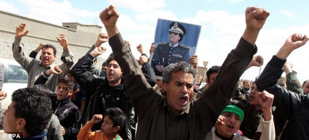 Libyans loyal to Gaddafi gather during a government-guided tour for journalists in Bani Walid, southeast of Tripoli Read more: http://www.dailymail.co.uk/news/article-1369452/Libya-Fighter-jets-shoot-Gaddafi-warplane-regimes-troops-parade-charred-bodies.html#ixzz1HWnUeHl2