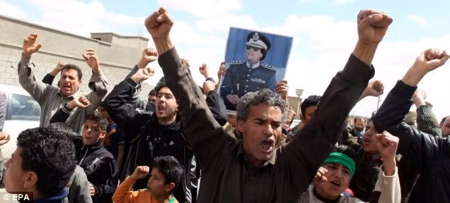 Libyans loyal to Gaddafi gather during a government-guided tour for journalists in Bani Walid, southeast of Tripoli Read more: http://www.dailymail.co.uk/news/article-1369452/Libya-Fighter-jets-shoot-Gaddafi-warplane-regimes-troops-parade-charred-bodies.html#ixzz1HWnUeHl2