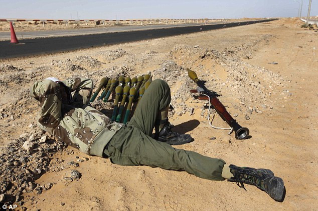 Taking a break: A rebel lies by the roadside next to a rocket-propelled grenade. The U.S. is apparently urging Saudi Arabia to arm anti-government fighters in Libya to oust Gaddafi Read more: http://www.dailymail.co.uk/news/article-1363780/U-S-asks-Saudi-Arabia-supply-Libyan-rebels-weapons-bids-oust-Gaddafi.html#ixzz1FvU3Mne0
