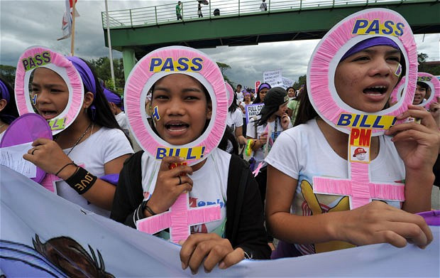 Các hoạt động kỷ niệm ngày Quốc tế Phụ nữ trên thế giới ảnh 6 Young women shout pro-reproductive health slogans during a protest march to parliament in Manila, amid a raging debate over a proposed law to allot annual funding for family planning. The Reproductive Health bill, which is backed by the president but strenuously opposed by the dominant Roman Catholic church, would oblige the government to fund mass contraception programmes.