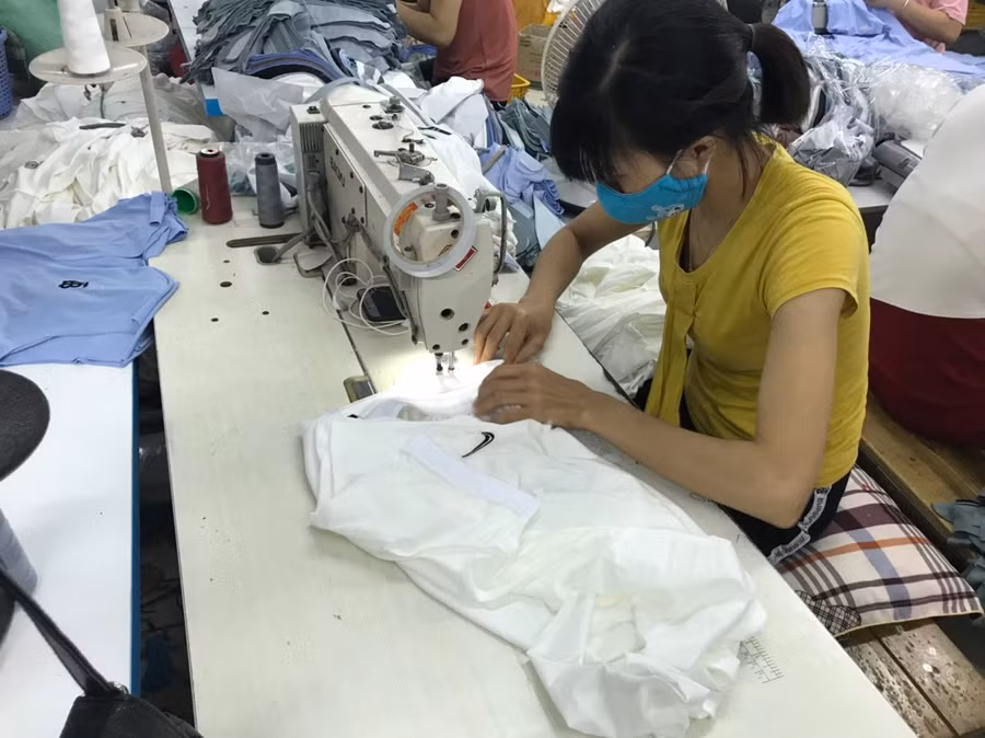 Công nhân tại công ty đang sản xuất áo phông giả mạo các nhãn hiệu nổi tiếng