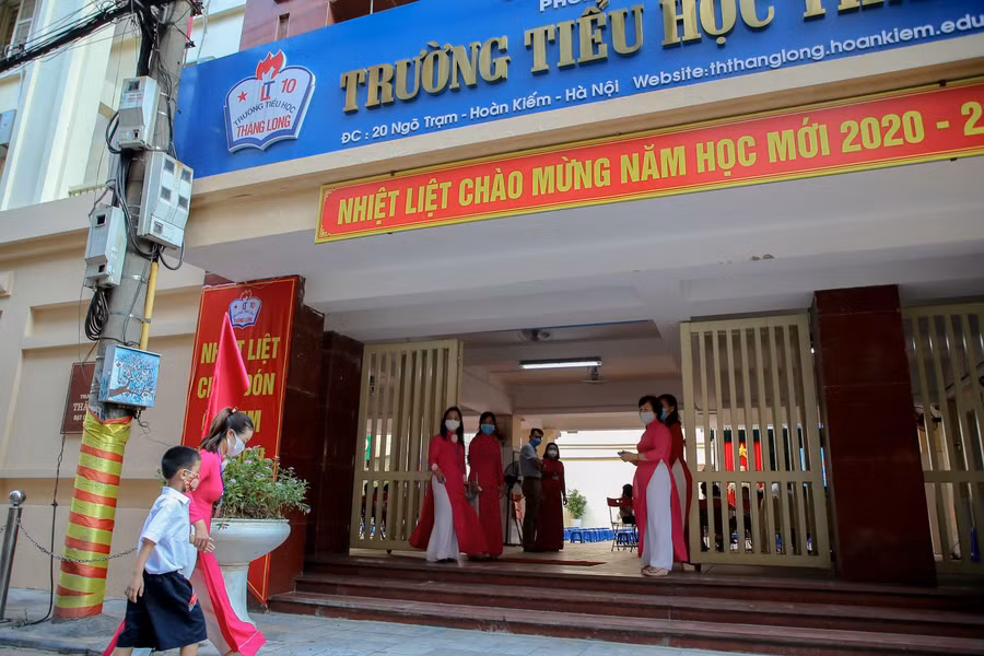 Những cô cậu học sinh lần đầu tiên bước chân vào ngôi trường tiểu học được các cô ân cần dắt tay vào cổng trường.