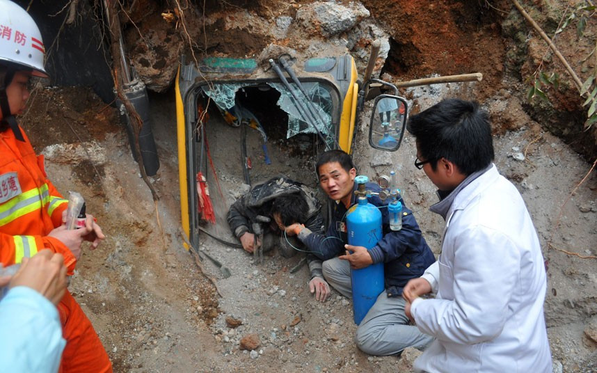 An excavator driver is rescued by firefighters after his machine was buried under a landslide for 90 minutes in Nanning, capital of southern China’s Guangxi Province. When firefighters arrived they used another excavator to remove some of the soil until the compartment of the buried machine was unearthed. Here they discovered the driver was buried up to his neck in soil. Firefighters then carefully began to clear away the soil around the man, but there was a second sudden landslide that buried the man again. Firefighters once again set about clearing the soil away and 90 minutes after he had been buried the man was pulled free. He was sent to hospital and is now out of danger.
