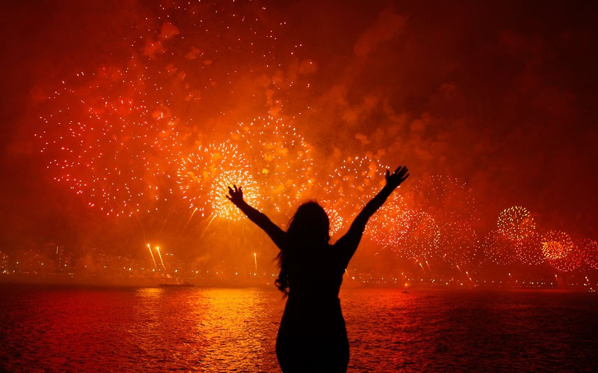 Những hình ảnh ấn tượng trong tuần ảnh 8 A woman celebrates the New Year as she watches fireworks exploding above Copacabana beach in Rio de Janeiro