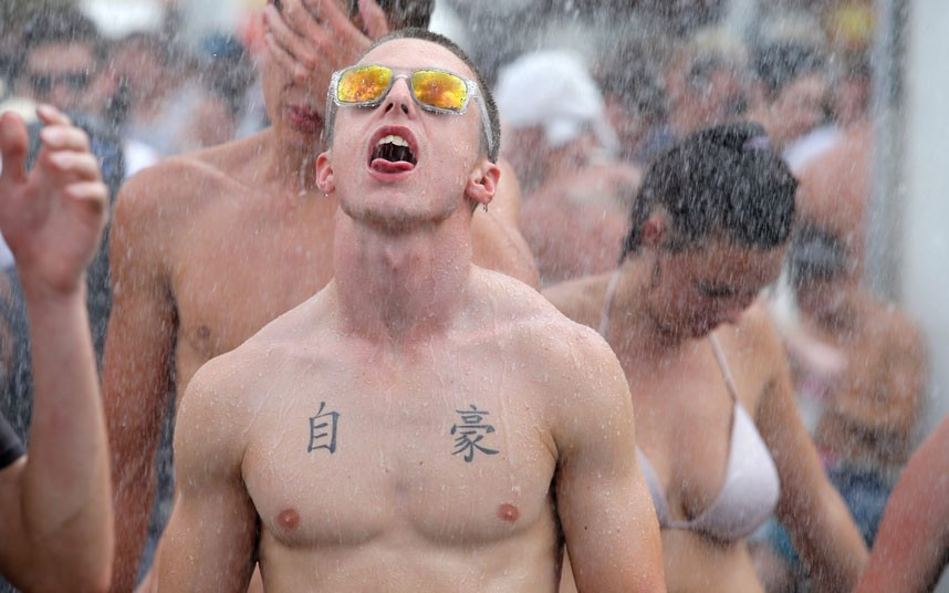 People try to escape the heat by standing under a fire hose at Big Day Out music festival in Sydney, where temperatures soared to nearly 46 degrees Celsius