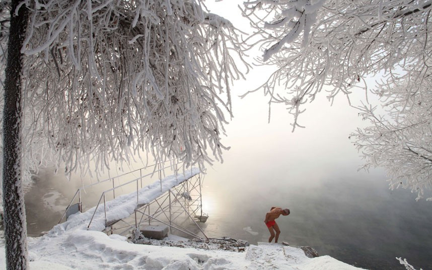 Retired teacher Gao Yinyu, 77, prepares to go for a swim in the nude at a snow-covered bathing spot in Jilin, in northeastern China