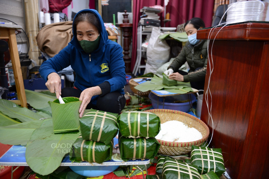 Trong nhà, mọi người vẫn tất bật gói bánh...