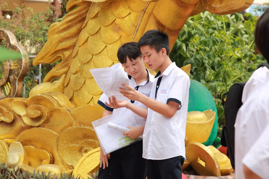 2 thí sinh tại điểm thi Trường THPT Lê Quý Đôn tranh thủ trao đổi lại đề thi. (Ảnh: TT)