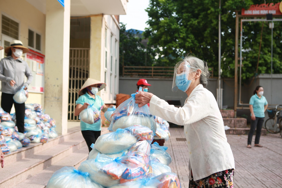 7h30 sáng 6/8 đã có rất đông người dân đến điểm nhà văn hóa số 1+3 của phường Phú Đô nhận gạo và mì tôm miễn phí.