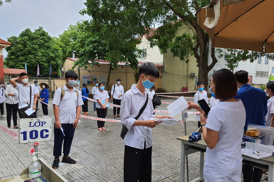 Thi sinh đo thân nhiệt và thực hiện giãn cách khi vào trường thi.