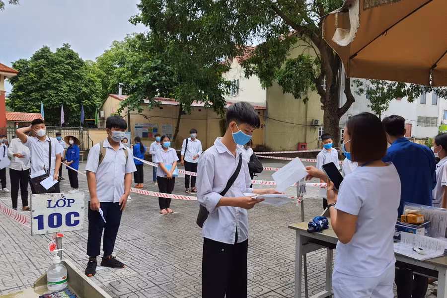 Thi sinh đo thân nhiệt và thực hiện giãn cách khi vào trường thi.