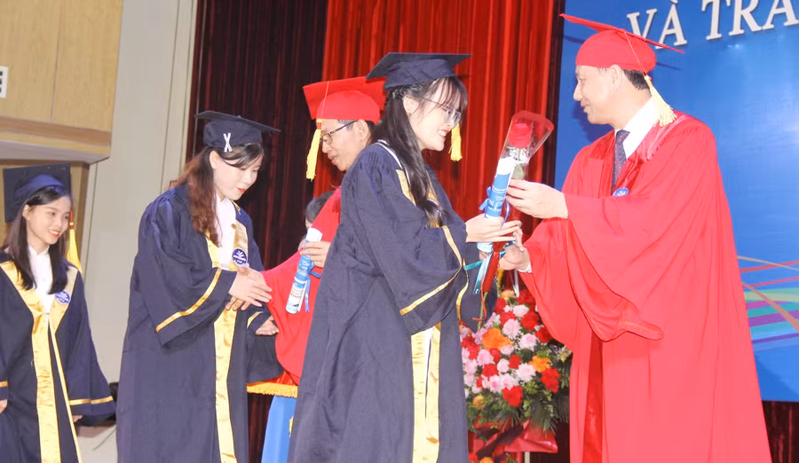 GS.TS Nguyễn Văn Minh - Hiệu trưởng và PGS.TS Nguyễn Đức Sơn - Phó Hiệu trưởng Trường ĐH Sư phạm Hà Nội (ngoài cùng bên phải) trao chúc thư và tặng hoa chúc mừng cho các tân cử nhân.