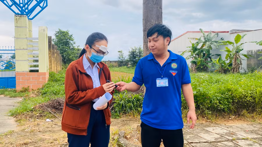 Tình nguyện viên hỗ trợ bút cho thí sinh.