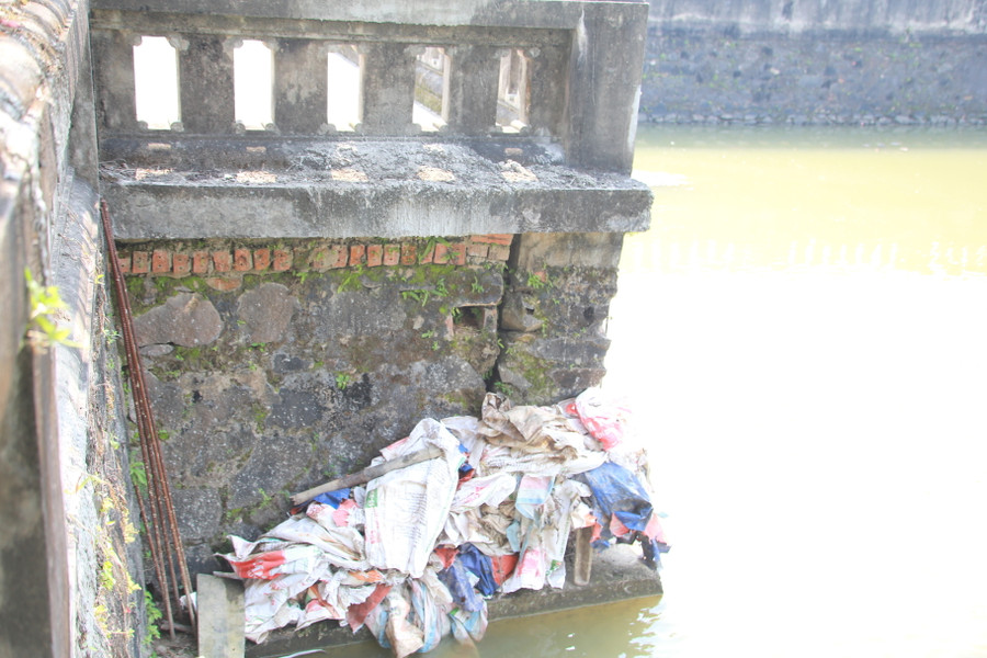 Các bao tải đựng vật liệu vương vãi khắp hồ được nhân viên Ban quản lý di tích thu gom.