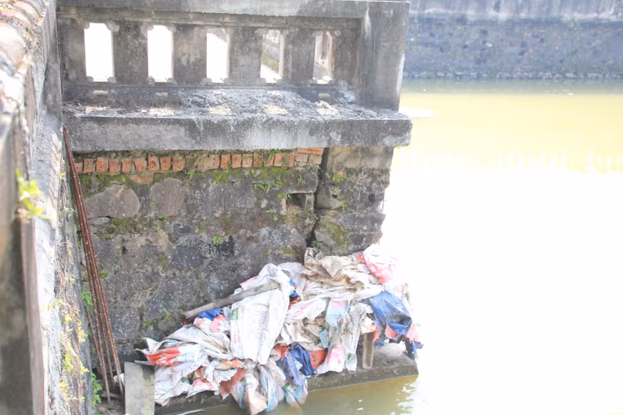 Các bao tải đựng vật liệu vương vãi khắp hồ được nhân viên Ban quản lý di tích thu gom.