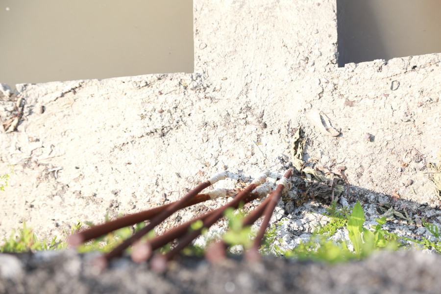 Hàng loạt cột sắt dựng đứng sát lan can bờ hồ, gây mất an toàn.