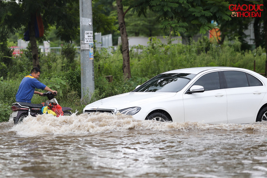 Ô tô đi qua điểm ngập tạo ra sóng nước, làm cho những người di chuyển bằng xe máy qua đây rất khó khăn
