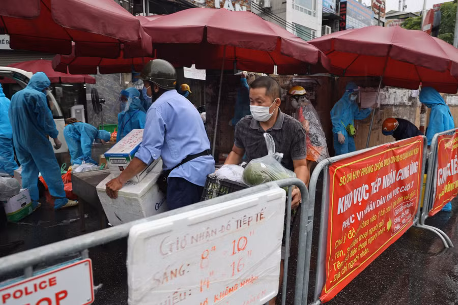 Người dân đội mưa đợi gửi lương thực, nhu yếu phẩm trong khu cách ly ảnh 6