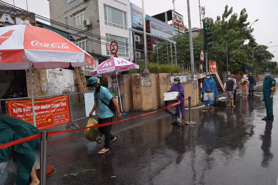 Người dân đội mưa đợi gửi lương thực, nhu yếu phẩm trong khu cách ly ảnh 4