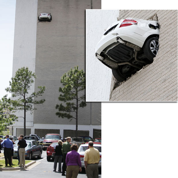 Chùm ảnh: Những "điểm đậu" hy hữu của xe hơi ảnh 3 A Mercedes hangs from the 7th floor parking garage at the Bank of America in Oklahoma. The car backed through the wall after the driver’s foot stuck on the accelerator. Debris rained down to a parking lot below, damaging several cars. No injuries were reported