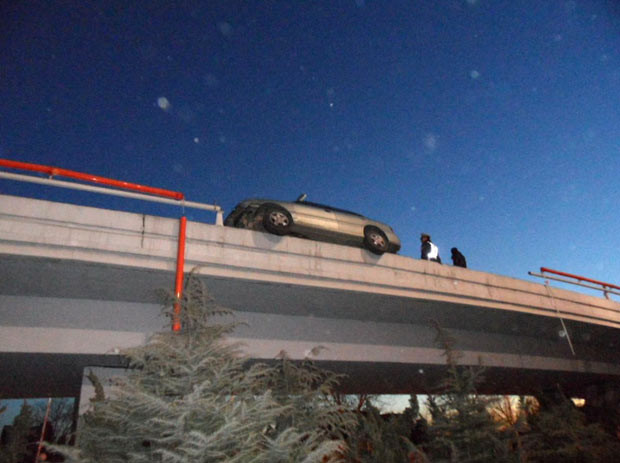 Chùm ảnh: Những "điểm đậu" hy hữu của xe hơi ảnh 9 A car teeters on the edge of a flyover in Tianjin, China after the driver swerved in an effort to avoid hitting another car. The vehicle came to rest with two wheels hanging over the edge of the road, with a 5-metre drop to the ground below it.