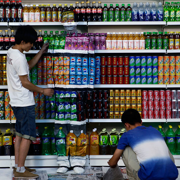 Chinese artist Liu Bolin is painted to blend into rows of drinks in his artwork entitled 