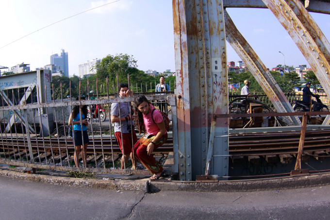 Khách du lịch chui qua rào chắn bị hỏng để vào trong khu vực đường ray tàu trên cầu Long Biên. Khách du lịch chui qua rào chắn bị hỏng để vào trong khu vực đường ray tàu trên cầu Long Biên.