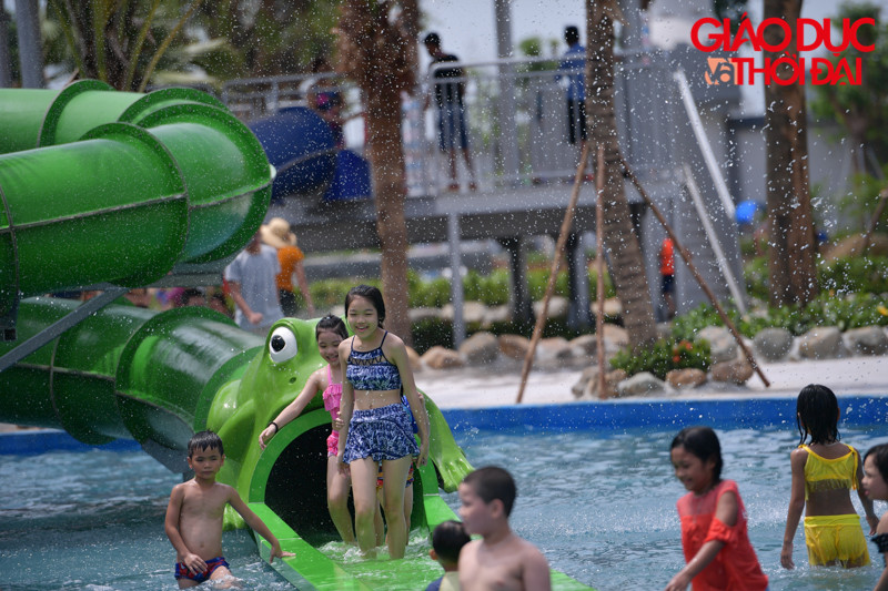 Nhiều trẻ nhỏ vô tư chơi đùa trên miệng ống trượt.