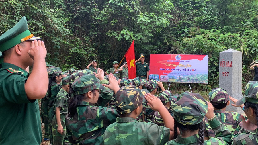 Các học sinh nghiêm trang trước cột mốc quốc giới.