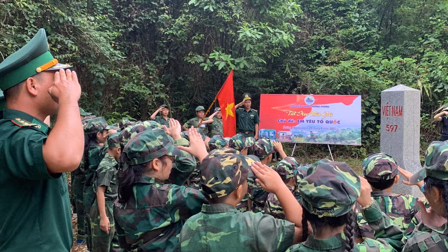 Các học sinh nghiêm trang trước cột mốc quốc giới.