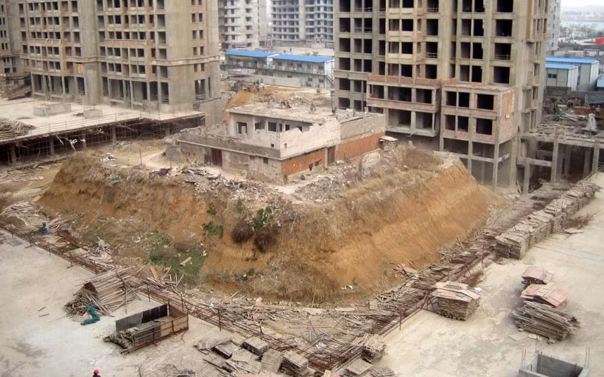 A couple’s home in Zaozhuang, northern China’s Shandong Province has been left on its own isolated ’island’ after real estate developers dug out the ground around it. Niu Chuangen and his wife Zhang Zhongyun, both in their 60s, have been living on this island without water and electricity since 2009 when a local developer started to build high-rise residential buildings in the area. Niu said he didn’t sign the compensation contract as the offered amount was too little. So Niu and his wife stayed and not only was the earth around their home removed but they say they have been intimated by gangsters and have had to fend off various attempts to illegally demolish their house.