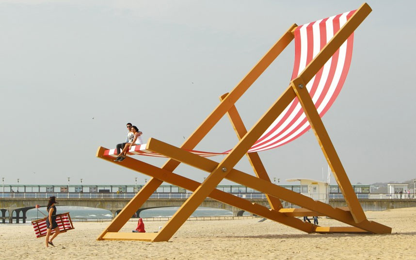 A couple sit it what is expected to be confirmed as the world’s largest deckchair on Bournemouth Beach. The deck chair measures eight and a half metres tall by five and a half metres wide, and weighs almost six tonnes. This has been commissioned by Pimm’s in celebration of the official start of British Summer Time.