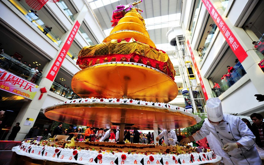 Những hình ảnh ấn tượng trong tuần ảnh 3 A shopping mall in Luoyang, central China’s Henan Province, has set a new world record by creating a huge 8m high cake. The eight-layer cake used 500kg of eggs, 260kg of flour, 200kg of cream, 100kg of fruit and 80kg of chocolate. The final product weighed nearly 2 tons, with each layer supported by round metal plate. It took 20 chefs 24 hours to make the cake, which broke the previous Guinness World Record of a 7.8m, made in Paris in 2010. Once the record had been confirmed the cake was shared out among 3,000 people.