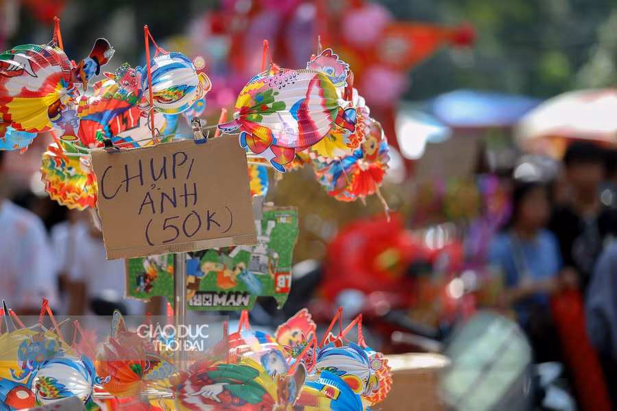 Nhiều tấm biển ghi rõ giá chụp ảnh khi không mua hàng được tiểu thương tại Hàng Mã treo.