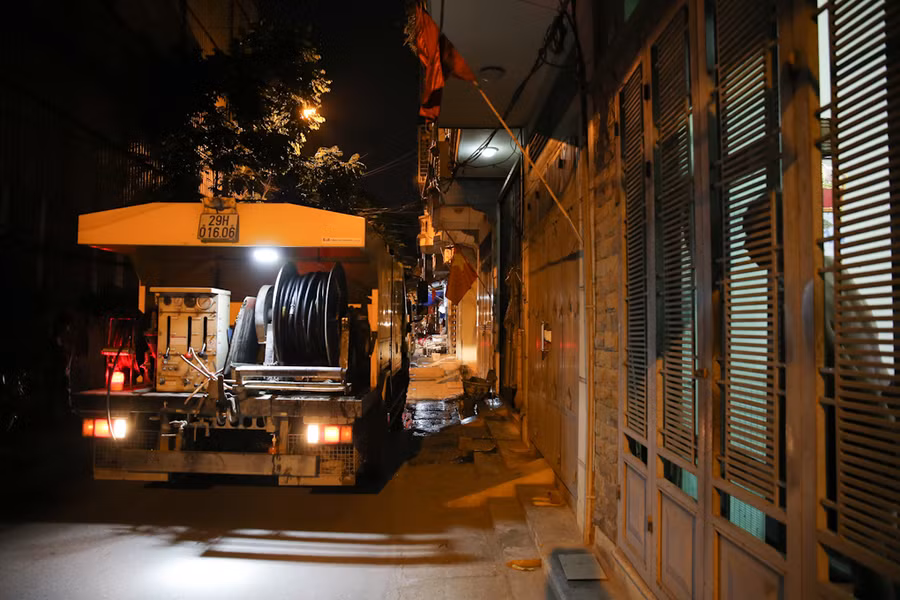 Các công nhân khơi thông cống rãnh, thoát nước thải, hút bùn ở ngõ 85, ngõ 192 phố Hạ Đình, ngõ 342 Khương Đình.