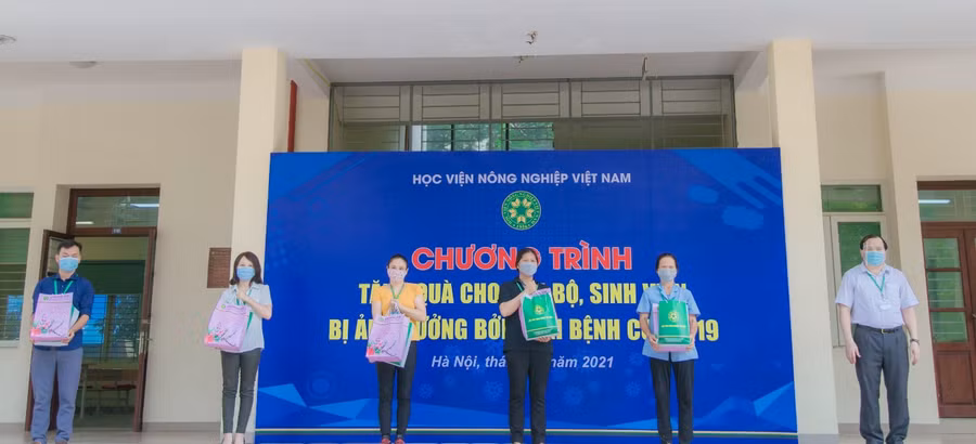 TS Vũ Ngọc Huyên Phó Giám đốc Học viện Nông nghiệp Việt Nam trao các suất quà cho cán bộ và sinh viên Học viện.