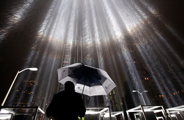 A worker holds an umbrella while adjusting beams of the Tribute in Lights ahead of the tenth anniversary of the September 11 terrorist attacks in New York City. The Tribute in Light is comprised of eighty-eight 7,000-Watt searchlights that beam into the sky near the site of the World Trade Center in remembrance of the September 11 attacks. 
