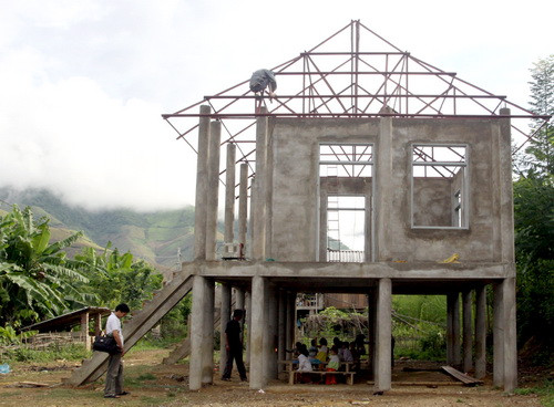 Dưới cô trò học, còn trên thì thợ sắt đang thi công phần mái