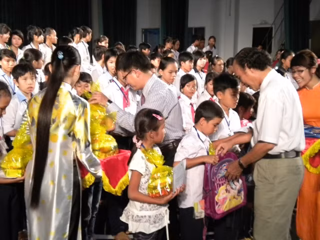 Đại diện nhà tài trợ của Tổ chức Comp Assion International trao tặng quà cho các em 